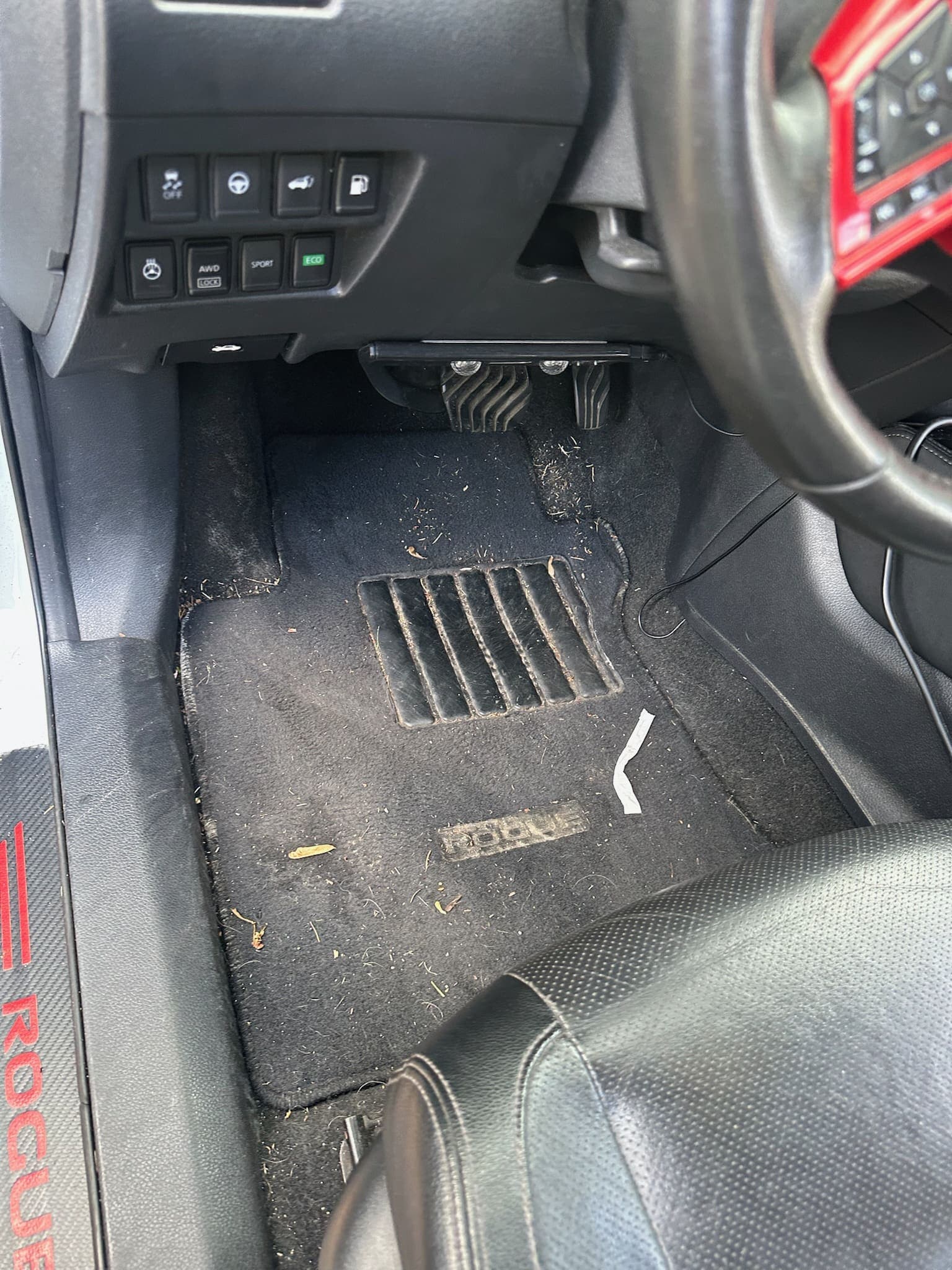 Nissan Rogue driver-side carpet covered in dirt and debris before a Freeman's detail